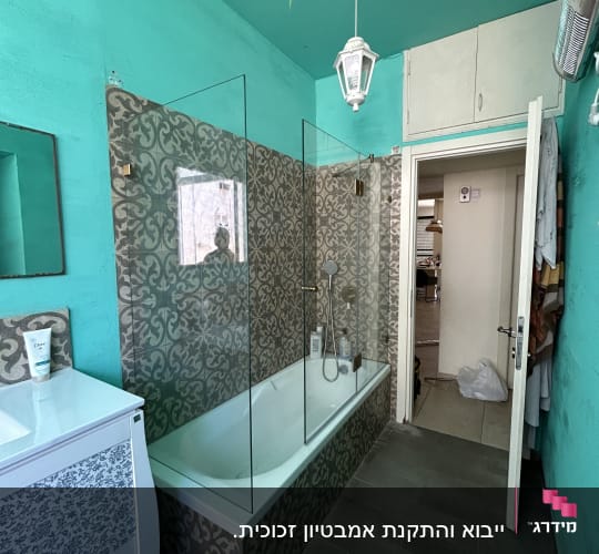 אמבטיה עם דלת זכוכית ומקלחת יד